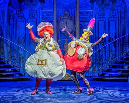 Cinderella's meanie stepsisters strike a pose. Brighouse & Rastrick are both wearing extravagant outfits that look like oversized purses and big colourful wigs with hats.