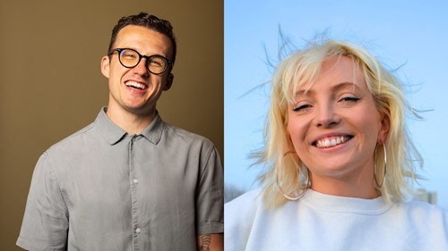 Side-by-side portraits of two smiling comedians. On the left, a man with short dark hair, wearing glasses and a light grey button-up shirt, stands against a plain tan background. On the right, a woman with platinum blonde hair and fringe, wearing hoop earrings and a fluffy white top, poses with her chin resting on her fists, smiling in front of a dark background with purple lighting.