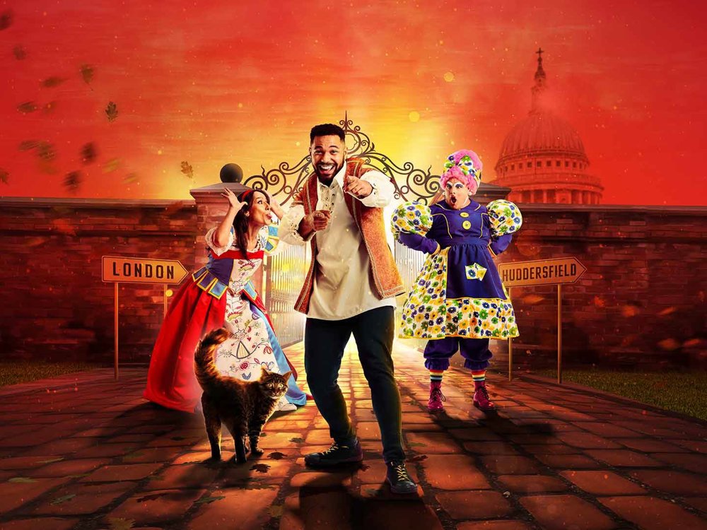 Promotional poster for the pantomime 'Dick Whittington' featuring three characters: Dick Whittington in the centre, a woman in a colourful dress on the left, and a character in a traditional British Pantomime Dame costume on the right. A cat stands in the foreground. The background includes signs pointing to 'London' and 'Huddersfield' with the dome of St. Paul's Cathedral visible.