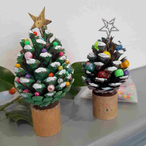Hand crafted Christmas tree designs made out of painted pine cones
