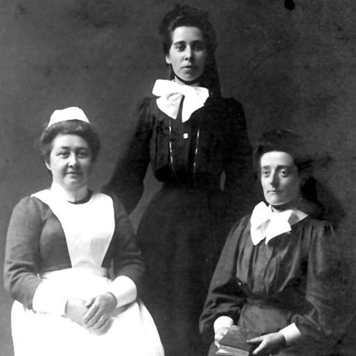 A photograph of three women who lived at the mission. One is wearing a nurse-like uniform, the other are in all black with white bows.