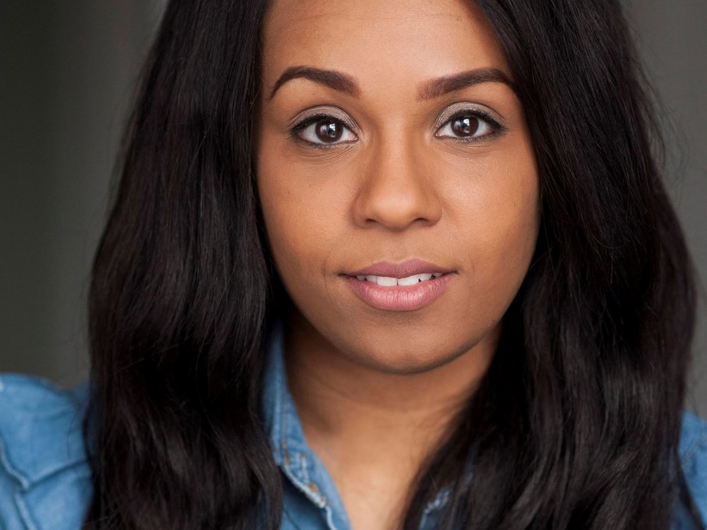 Headshot of Shorelle Hepkin. She has long black hair and wears a denim shirt, looking directly at the camera with a neutral expression. 