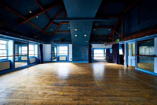 Our Attic Theatre, a large room with blue walls and wooden floor with lots of natural light. An ideal space for rehearsals and workshops.