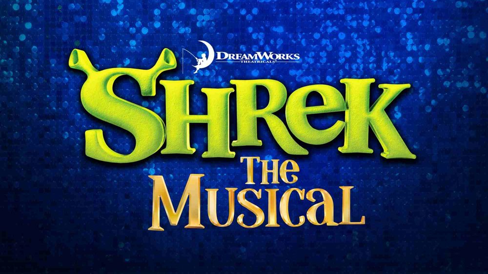 Promotional artwork for Shrek the Musical, featuring the large green “Shrek” logo with ogre ears above the gold words “The Musical.” The DreamWorks Theatricals logo appears above, set against a sparkling deep-blue background.