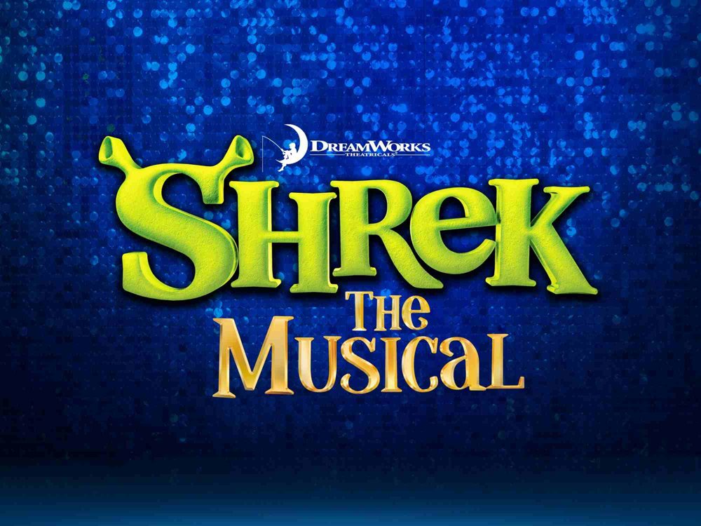 Promotional artwork for Shrek the Musical, featuring the large green “Shrek” logo with ogre ears above the gold words “The Musical.” The DreamWorks Theatricals logo appears above, set against a sparkling deep-blue background.