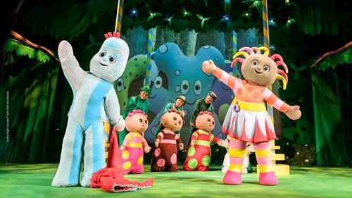 In the Night Garden characters Upsy Daisy and Igglepiggle in full life-size costumes waving on stage. 