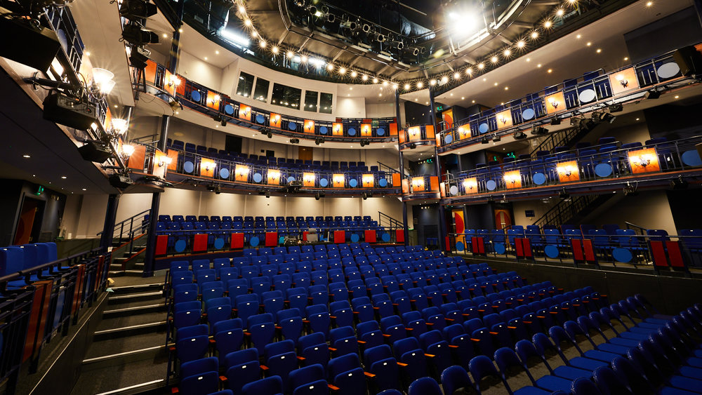 View of the Lawrence Batley Theatre auditorium, a modern space with 14 rows of 18 seats downstairs, and 2 balconies with seats on the sides and forward facing