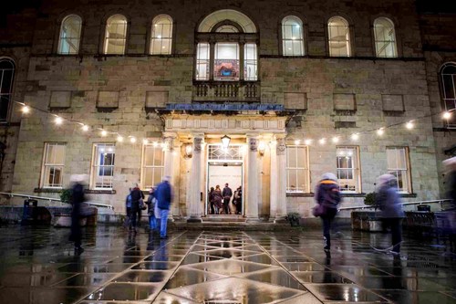 A busy courtyard leading into a building.