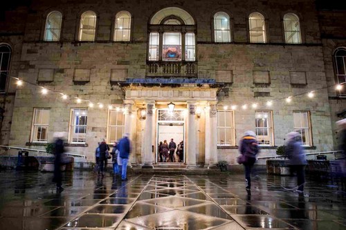 A busy courtyard leading into a building. 