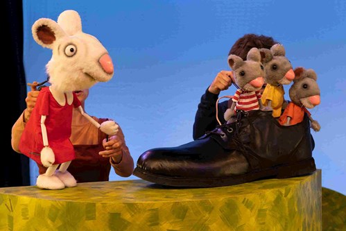 Three baby mice puppets stand together in the Smartest Giant's shoe. 
