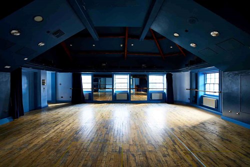 Our Attic Theatre, a large room with blue walls and wooden floor with lots of natural light. An ideal space for rehearsals and workshops