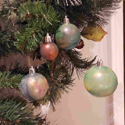 Hand crafted marbled bauble baubles hanging from a Christmas tree