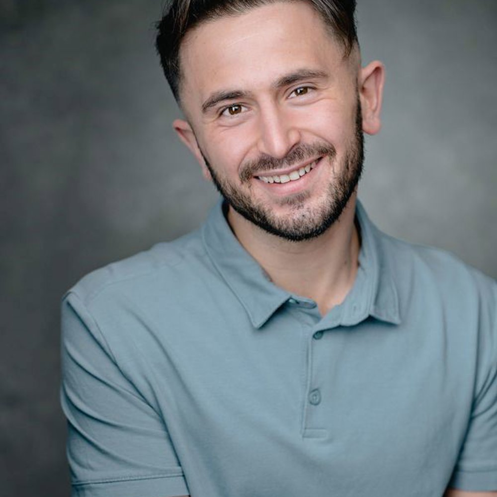 Headshot of Thomas Cotran. He has short dark hair, wears a light blue polo shirt, and smiles warmly at the camera.