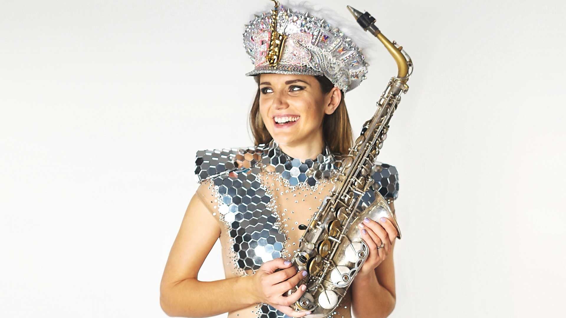 Photo of Ellie Sax wearing sequins carrying her saxophone