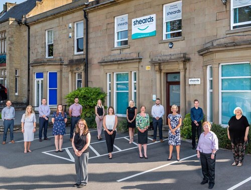 Group shot of the team at Sheards standing outside their office in the sun