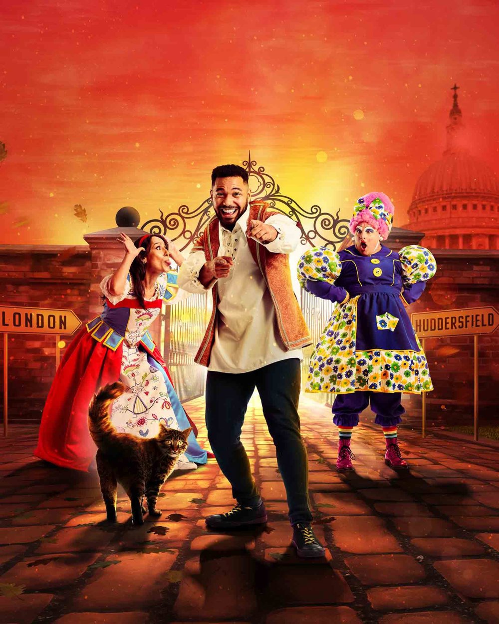 Promotional poster for the pantomime 'Dick Whittington' featuring three characters: Dick Whittington in the centre, a woman in a colourful dress on the left, and a character in a traditional British Pantomime Dame costume on the right. A cat stands in the foreground. The background includes signs pointing to 'London' and 'Huddersfield' with the dome of St. Paul's Cathedral visible.